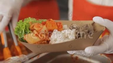 在街头美食节上，卖家正在把日本食物放进纸板盘里。